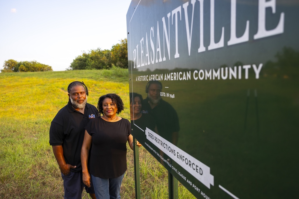 Ricky Johnson and Bridgette Murray, who work to raise awareness of issues caused by pollution, pose in front of a sign for the Pleasantville area of Houston, Saturday, Aug. 17, 2024.