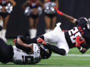 Jacksonville Jaguars defensive end Trevis Gipson (50) hits Atlanta Falcons running back Carlos Washington Jr. (28) in the first half of an NFL preseason footballl game, Friday, Aug. 23, 2024, in Atlanta.