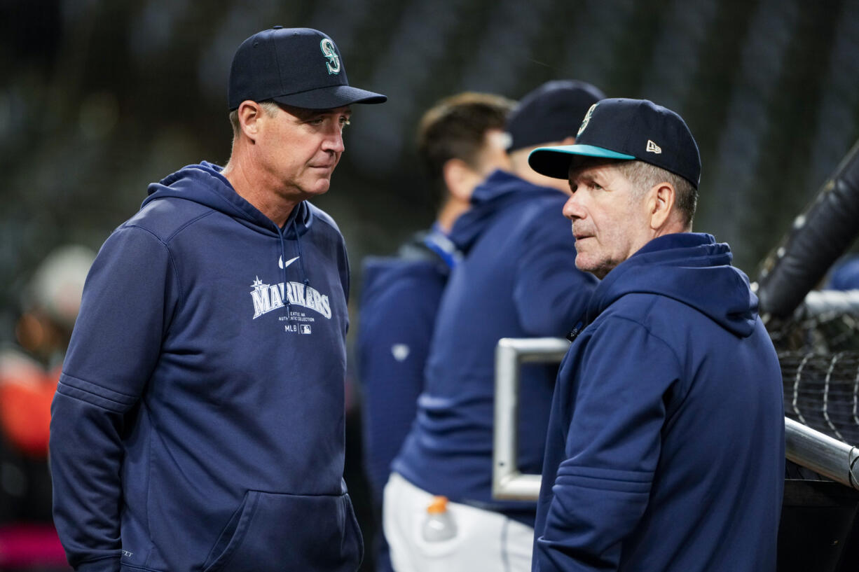 Seattle Mariners manager Dan Wilson, left, looks on next to hitting coach Edgar Martinez, right, during batting practice before a baseball game against the San Francisco Giants, Friday, Aug. 23, 2024, in Seattle.