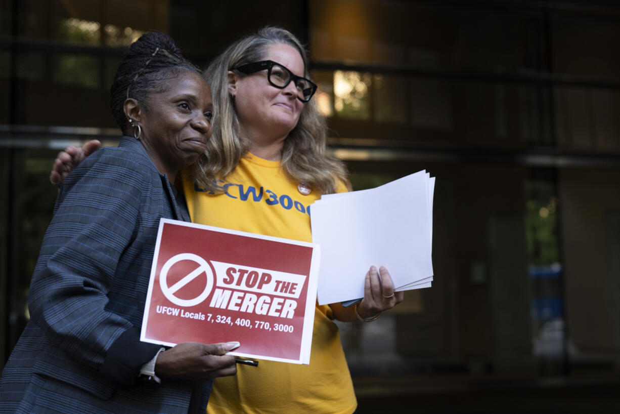 Faye Guenther, president of local UFCW 3000, hugs Carol McMillian, bakery manager at Kroger-owned King Soopers and member of Local 7, after a news conference about the Kroger and Albertsons merger outside the federal courthouse on Monday, Aug. 26, 2024, in Portland, Ore.