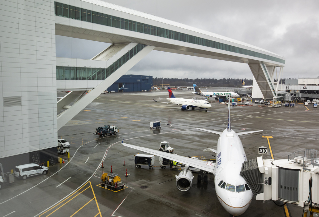 FILE - Planes taxi under the aerial passenger walkway at Seattle-Tacoma International Airport, March 3, 2022, in Seattle.