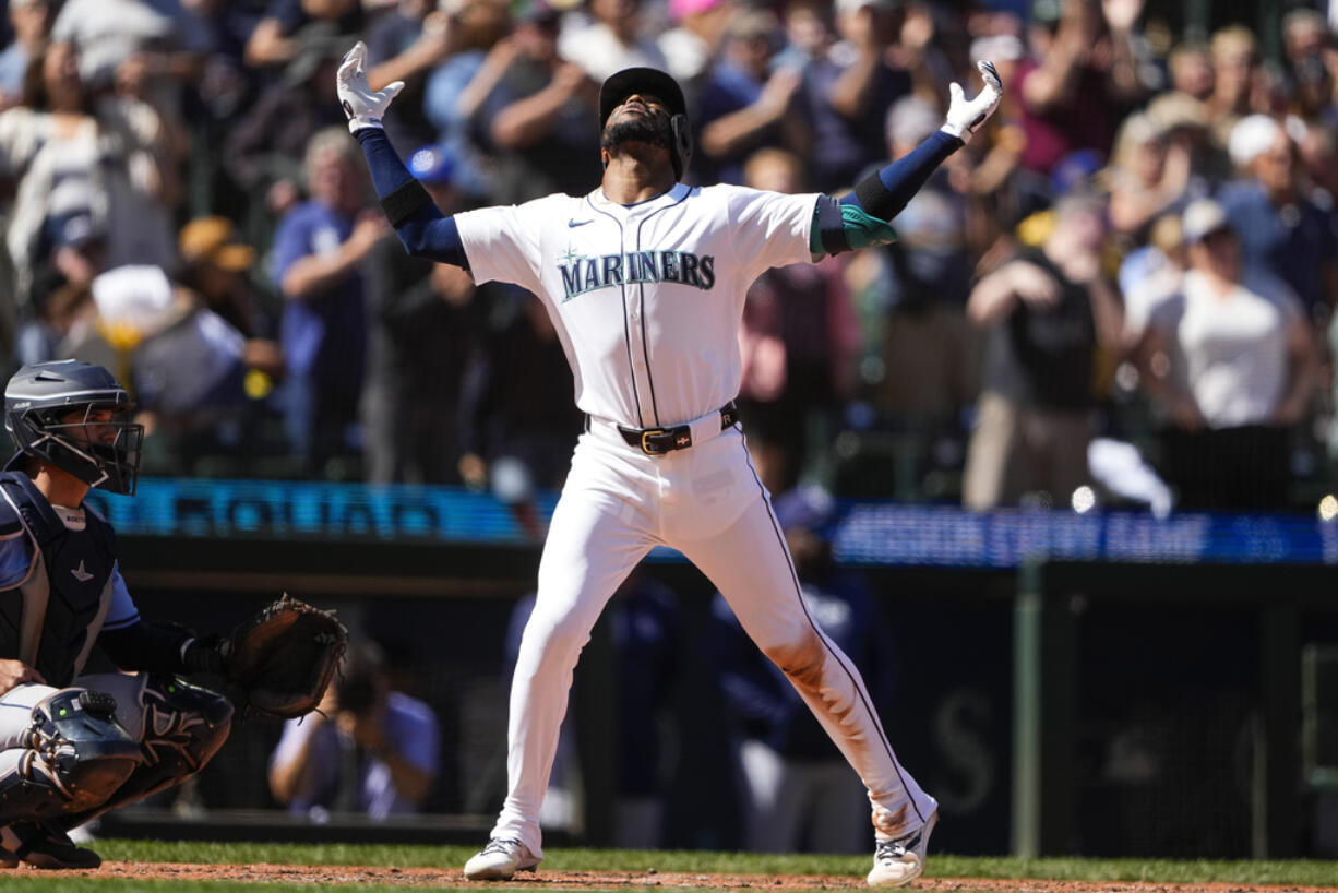 Seattle Mariners' Victor Robles reacts as he crosses home plate after hitting a two-run home run as Tampa Bay Rays catcher Ben Rortvedt, left, looks on during the fifth inning of a baseball game, Wednesday, Aug. 28, 2024, in Seattle.