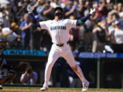 Seattle Mariners' Victor Robles reacts as he crosses home plate after hitting a two-run home run as Tampa Bay Rays catcher Ben Rortvedt, left, looks on during the fifth inning of a baseball game, Wednesday, Aug. 28, 2024, in Seattle.