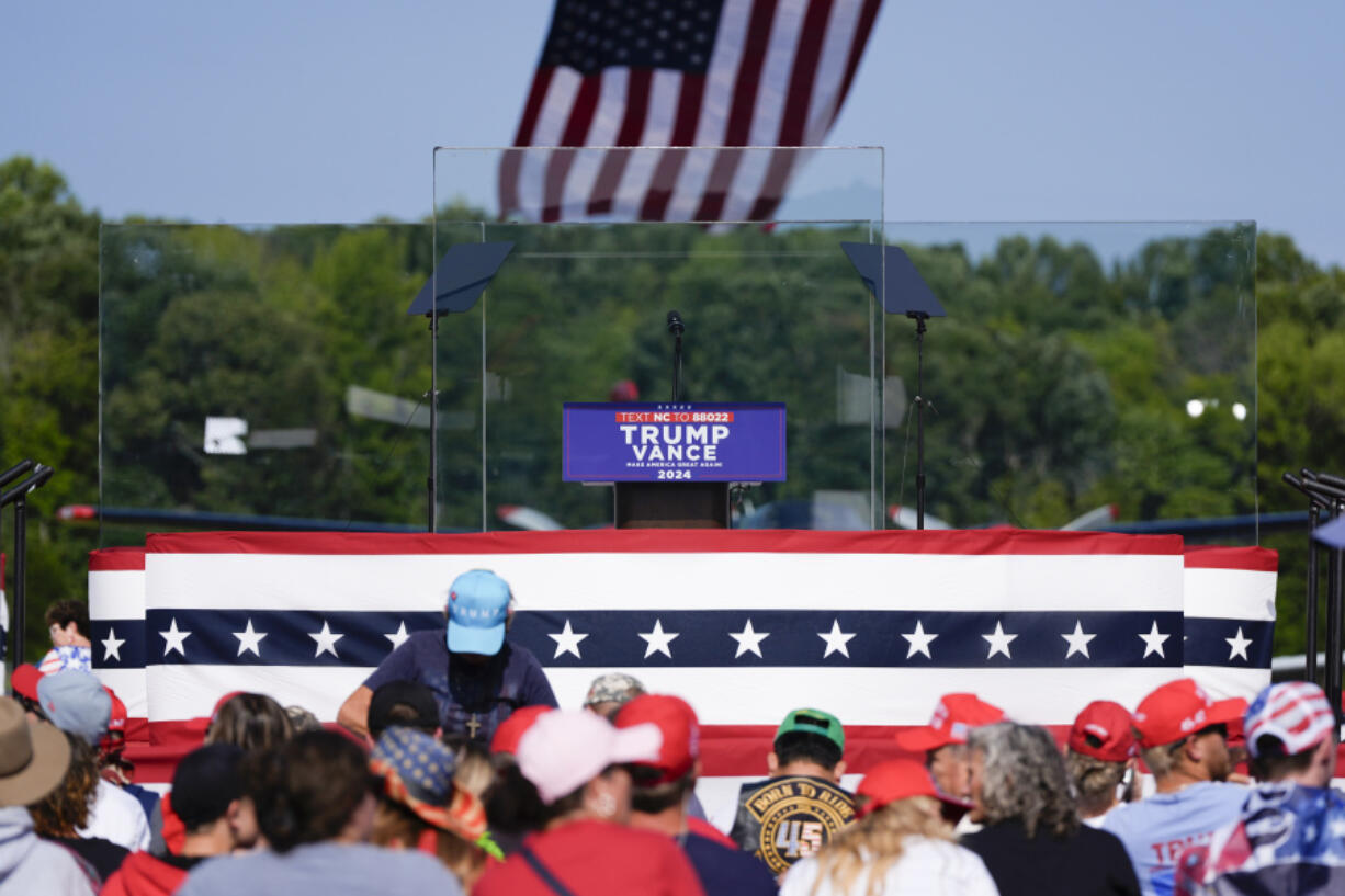 An outdoor stage is encased in bulletproof glass as supporters arrive to hear Republican presidential nominee former President Donald Trump speak Wednesday in Asheboro, N.C.