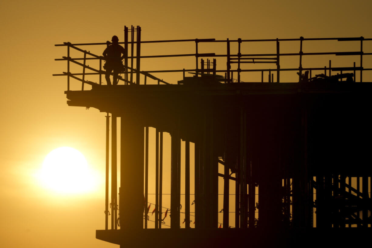 Construction workers start their day as the sun rises on the new Republic Airlines headquarters building in Carmel, Ind., Tuesday, Aug. 27, 2024.