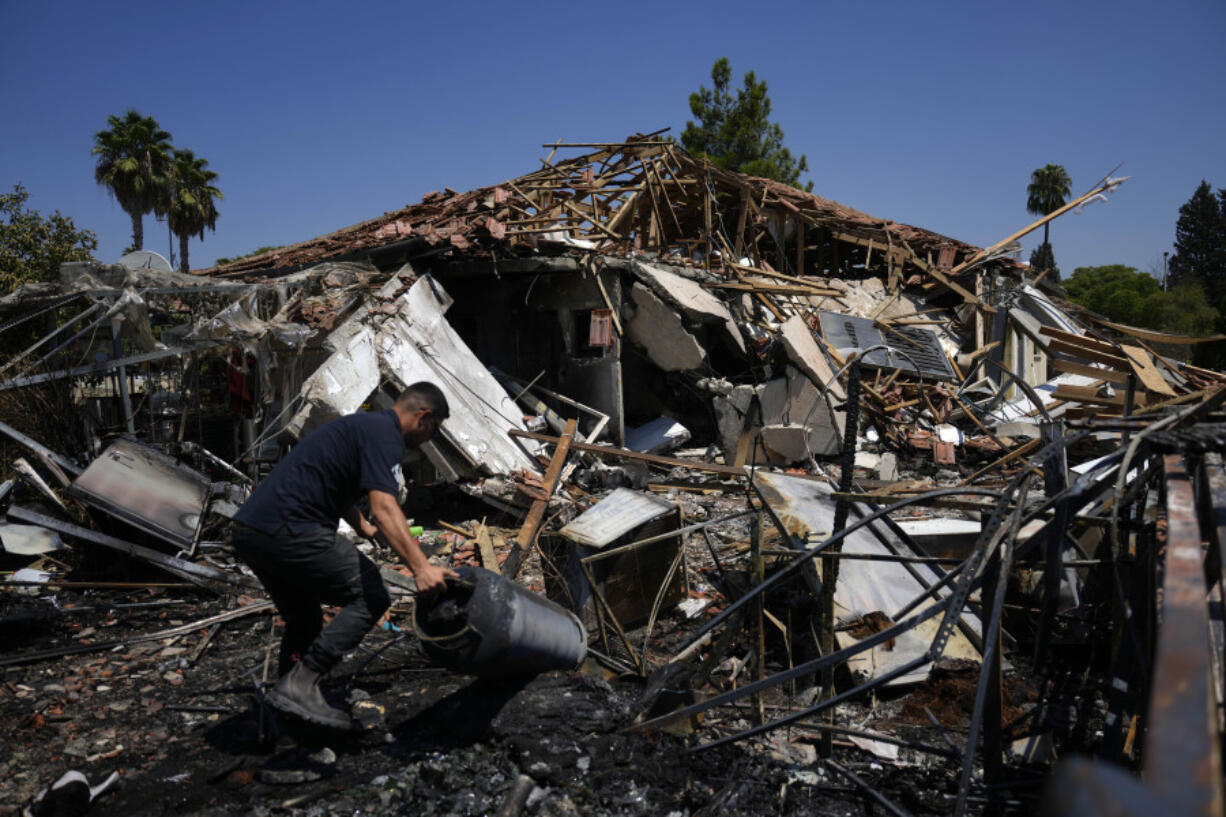 A man works next to a destroyed home Wednesday after rockets struck in Katzrin, in the Israeli-annexed Golan Heights. Lebanon&rsquo;s Hezbollah launched more than 50 rockets, hitting a number of private homes in the area.