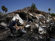 A man works next to a destroyed home Wednesday after rockets struck in Katzrin, in the Israeli-annexed Golan Heights. Lebanon&rsquo;s Hezbollah launched more than 50 rockets, hitting a number of private homes in the area.