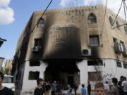 Palestinians stand outside a heavily damaged mosque following an Israeli military operation in the West Bank refugee camp of Al-Faraa, Thursday, Aug. 29, 2024.