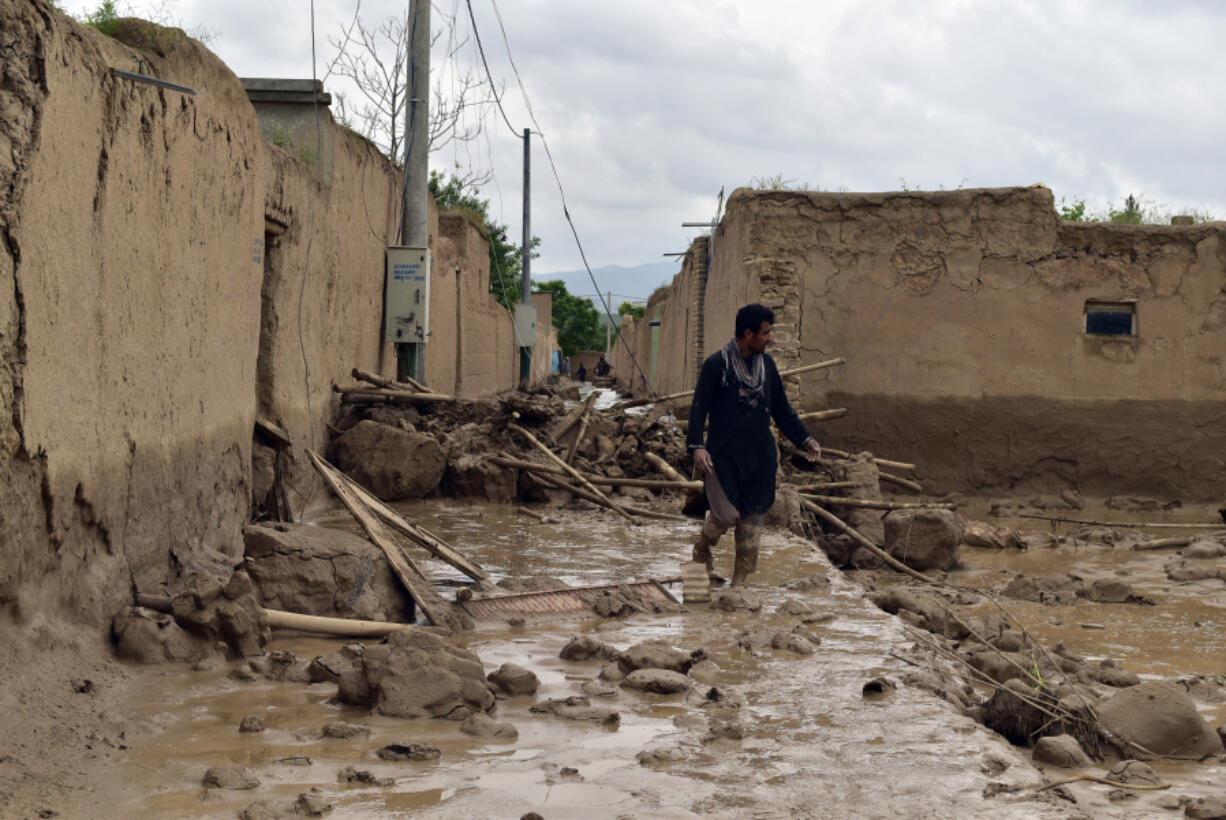 FILE -An Afghan man walks near his damaged home after heavy flooding in Baghlan province in northern Afghanistan, May 11, 2024.