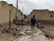 FILE -An Afghan man walks near his damaged home after heavy flooding in Baghlan province in northern Afghanistan, May 11, 2024.