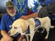 Alan Gurvitz, a volunteer with his therapy dog, Hope, a Labrador retriever, offered their service to passengers at the Philadelphia International Airport on Monday, Aug. 26, 2024, in Philadelphia.