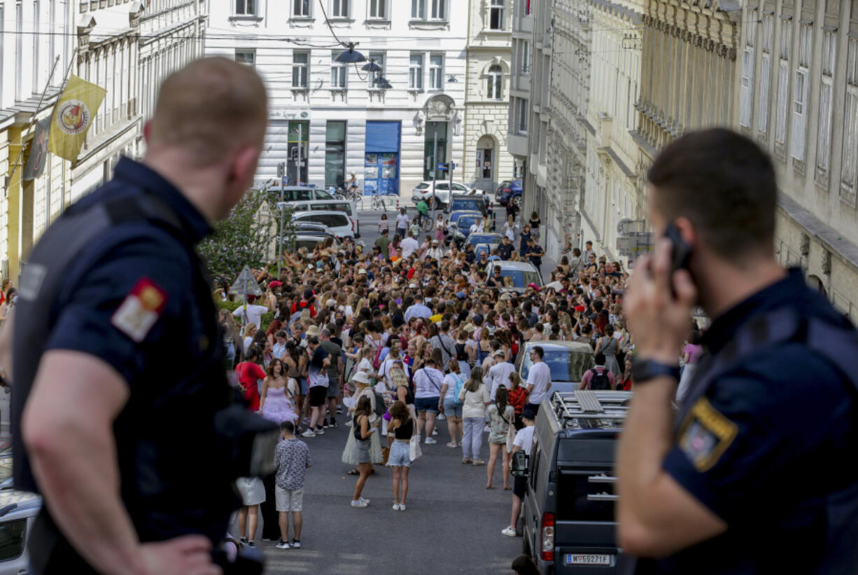 Austrian police officers watch swifts gathering in the city centre in Vienna on Thursday, Aug.8, 2024. Organizers of three Taylor Swift concerts in the stadium in Vienna this week called them off on Wednesday after officials announced arrests over an apparent plot to launch an attack on an event in the Vienna area such as the concerts.