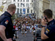 Austrian police officers watch swifts gathering in the city centre in Vienna on Thursday, Aug.8, 2024. Organizers of three Taylor Swift concerts in the stadium in Vienna this week called them off on Wednesday after officials announced arrests over an apparent plot to launch an attack on an event in the Vienna area such as the concerts.