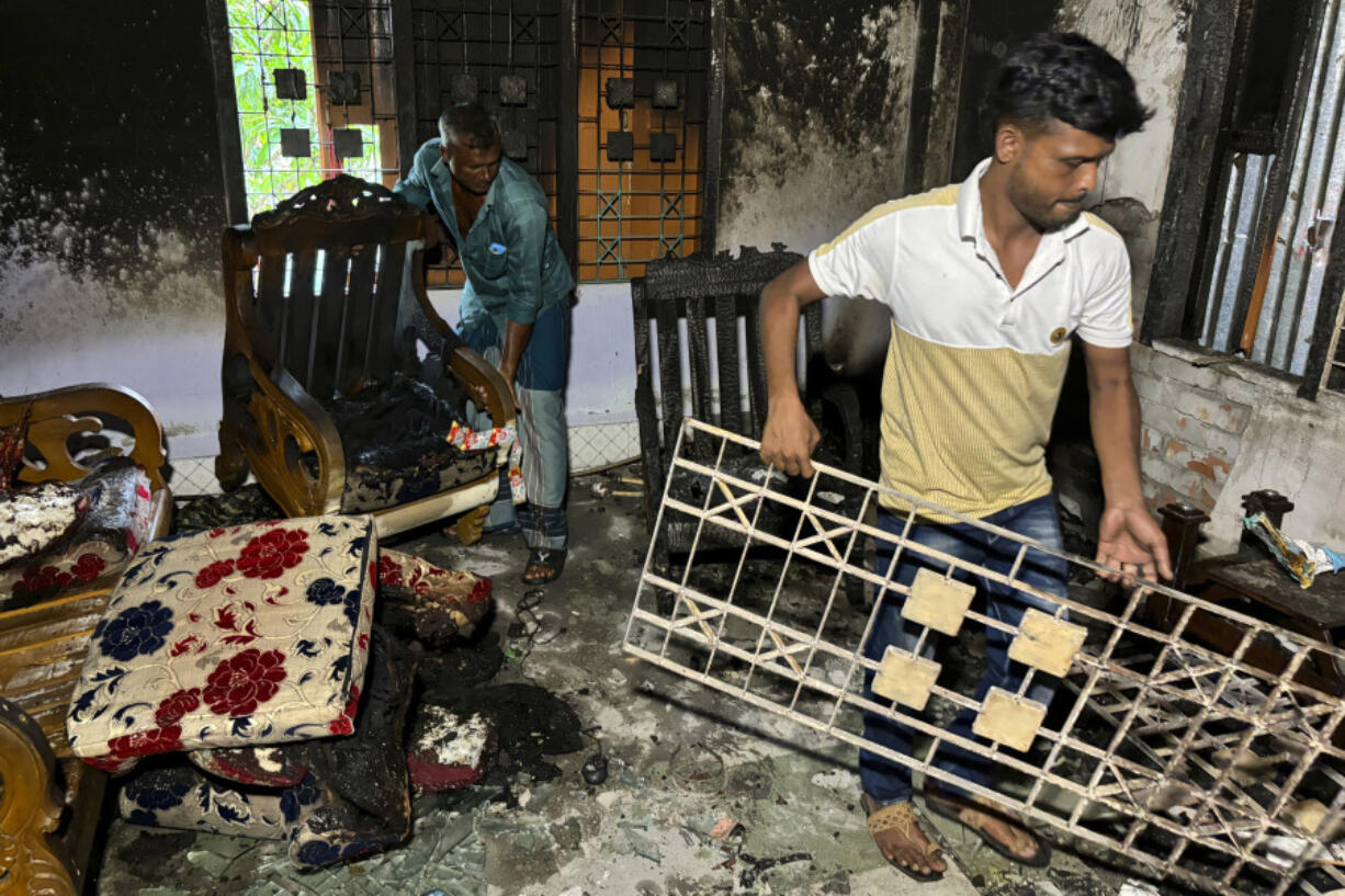 CORRECTS CITY TO BOTIAGHATA - Relatives salvage furniture from a house belonging to a supporter of Bangladesh&rsquo;s former prime minister that was burnt down by a mob, in Botiaghata, Khulna district, Bangladesh, Sunday, Aug. 11, 2024.