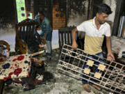 CORRECTS CITY TO BOTIAGHATA - Relatives salvage furniture from a house belonging to a supporter of Bangladesh&rsquo;s former prime minister that was burnt down by a mob, in Botiaghata, Khulna district, Bangladesh, Sunday, Aug. 11, 2024.