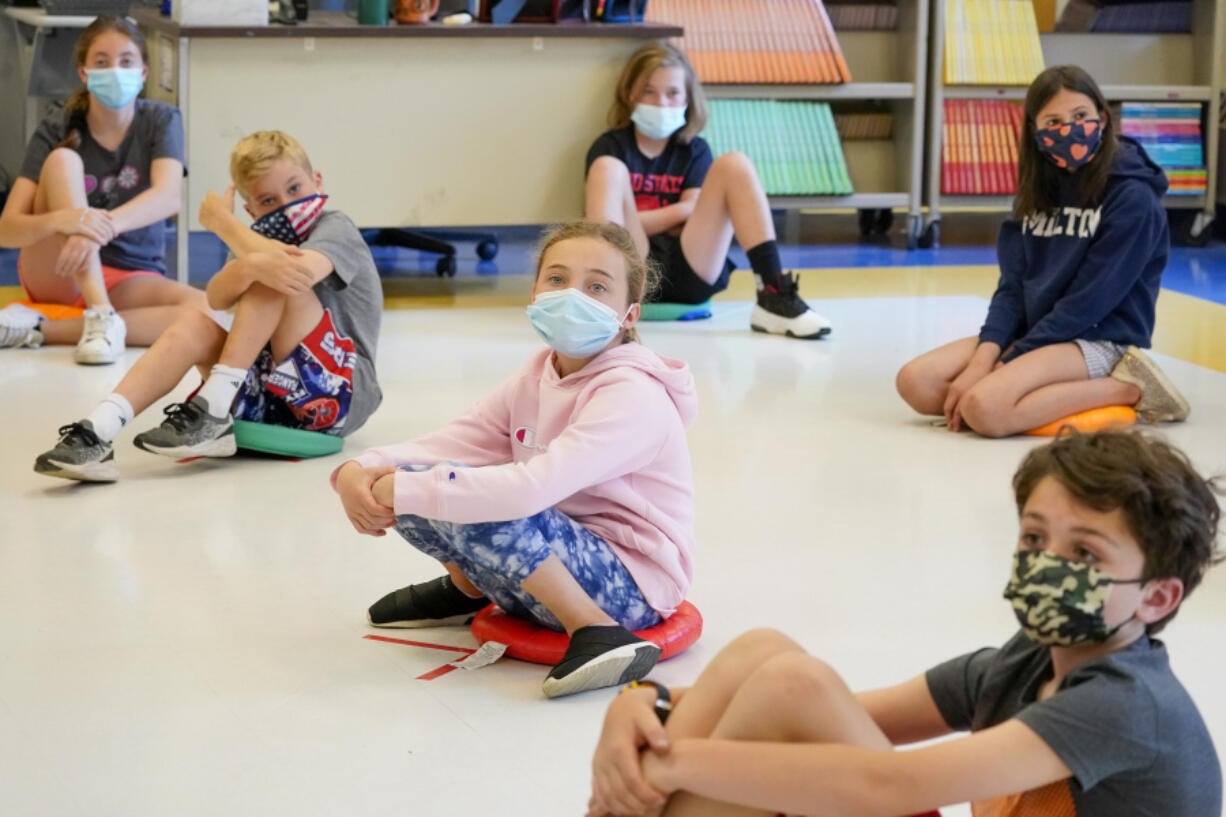 Fifth-graders wearing face masks are seated at proper social distancing during a music class at the Milton Elementary School in Rye, N.Y., on May 18, 2021.