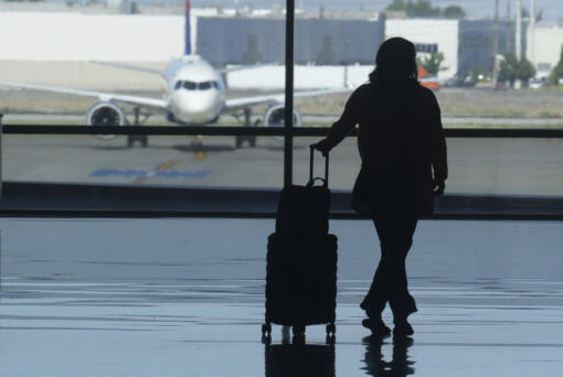 A holiday traveler looks out at a airplane at Salt Lake City International Airport, in Salt Lake City, July 3, 2024.