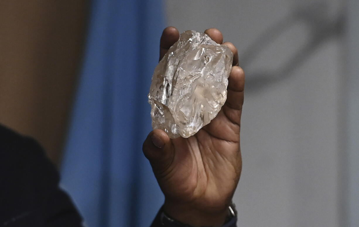 A person holds a 2,492-carat diamond which was found in the country and on show, in Gaborone,  Botswana, Thursday, Aug. 22, 2024.