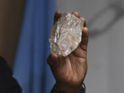 A person holds a 2,492-carat diamond which was found in the country and on show, in Gaborone,  Botswana, Thursday, Aug. 22, 2024.