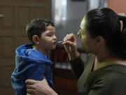 Janaina Silva gives a dose of liquid cannabidiol, or CBD, to her 4-year-old son Murillo after an epileptic seizure July 8 at her parents&rsquo; home in Guaruja, Brazil. Murillo takes regular doses of CBD that his mother acquires for free through Sao Paulo state&rsquo;s public health system.