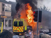 A police van buns as and unruly crowd clashed with police, Tuesday, July 30, 2024, in Southport, northwest England, near where three girls were stabbed to death in a dance class the day before. The violence erupted shortly after a peaceful vigil was attended by hundreds in the center of Southport to mourn the 13 victims of the stabbings, including seven still in critical condition.