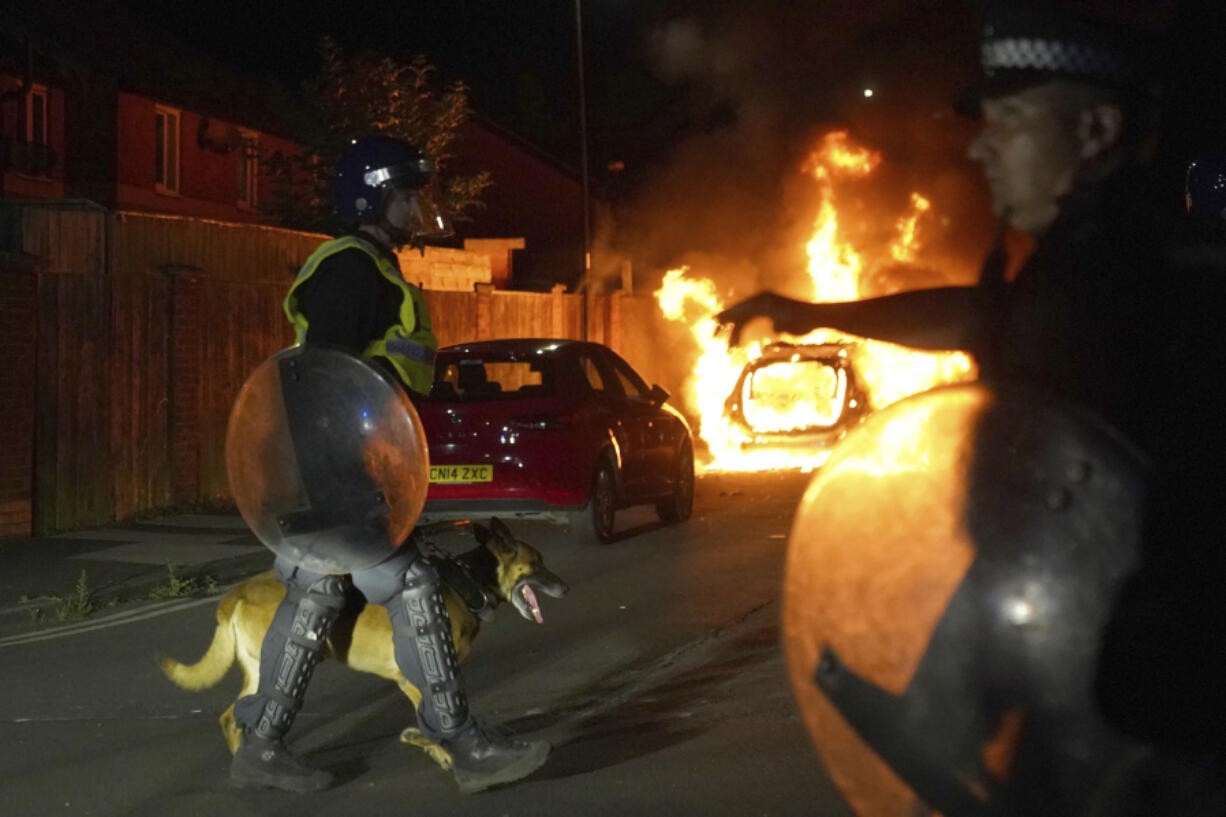 A police car burns as police officers are deployed on the streets of Hartlepool, England, following a violent protest in the wake of the killing of three girls who were fatally stabbed in northwest England, Wednesday, July 31, 2024. Far-right groups seek to stir anger over an attack they have sought to link &mdash; without evidence &mdash; to immigrants.