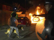 A police car burns as police officers are deployed on the streets of Hartlepool, England, following a violent protest in the wake of the killing of three girls who were fatally stabbed in northwest England, Wednesday, July 31, 2024. Far-right groups seek to stir anger over an attack they have sought to link &mdash; without evidence &mdash; to immigrants.