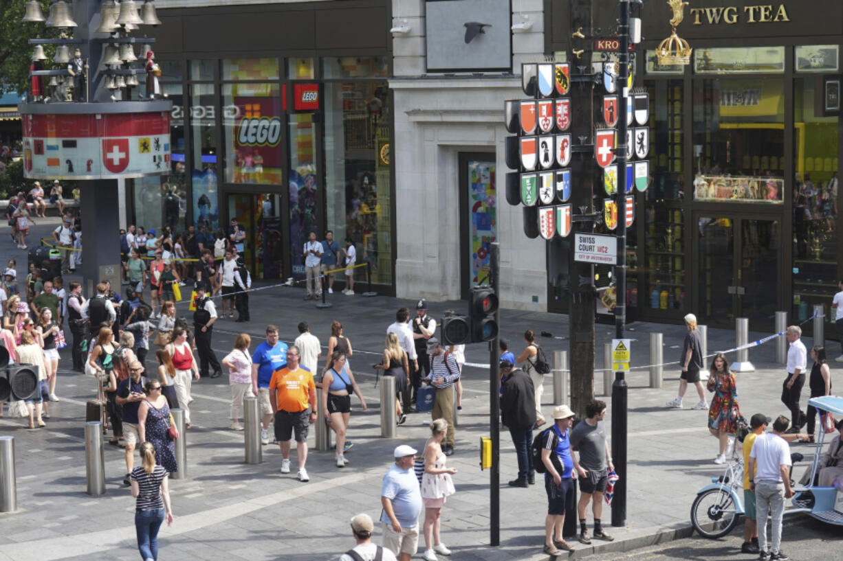 Police cordon off an area in Leicester Square, as a man was arrested with the accusation of stabbing an 11-year-old girl and 34-year-old woman, in London, Monday Aug. 12, 2024.