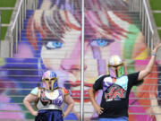 Kristina Broclebanl, left and Max Avatar Barnett who are Taylor Swift fans pose by a portrait of Swift painted on a stairway at Wembley Stadium in London, Wednesday, Aug. 14, 2024, ahead of a series of Taylor Swift concerts starting Thursday.