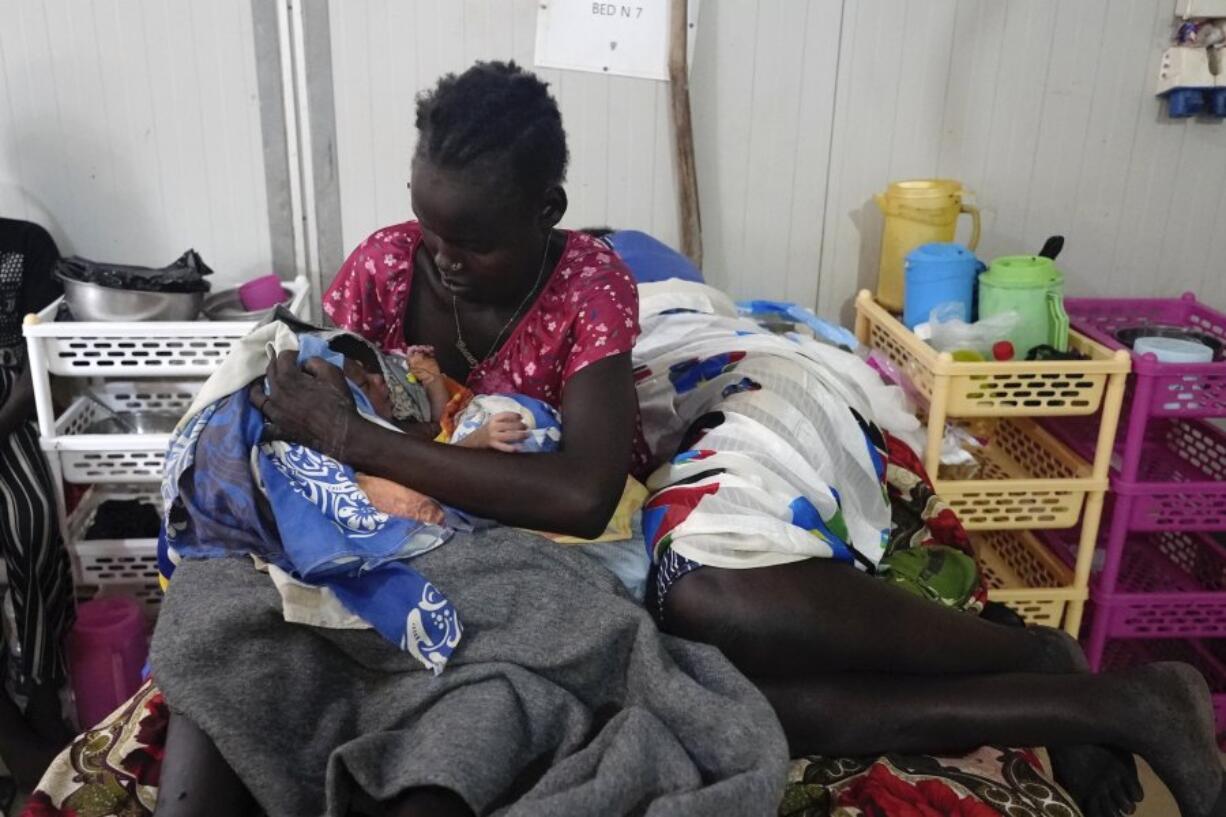 Nyalith Mauit, cradles her one-day old son on a bed in the Doctors Without Borders in Bentiu-run hospital in Bentiu, South Sudan, Monday, June 24,2024, after she lost one of her twins while giving birth. South Sudan&rsquo;s health system suffers, even though the relative peace gives many women easier access to care. The government allocates less than 2% of the national budget to the health ministry. Much of the health system is propped up by aid groups and the international community.