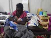 Nyalith Mauit, cradles her one-day old son on a bed in the Doctors Without Borders in Bentiu-run hospital in Bentiu, South Sudan, Monday, June 24,2024, after she lost one of her twins while giving birth. South Sudan&rsquo;s health system suffers, even though the relative peace gives many women easier access to care. The government allocates less than 2% of the national budget to the health ministry. Much of the health system is propped up by aid groups and the international community.