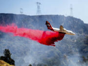 FILE - An air tanker drops retardant while trying to stop the Thompson Fire from spreading in Oroville, Calif., on Wednesday, July 3, 2024.