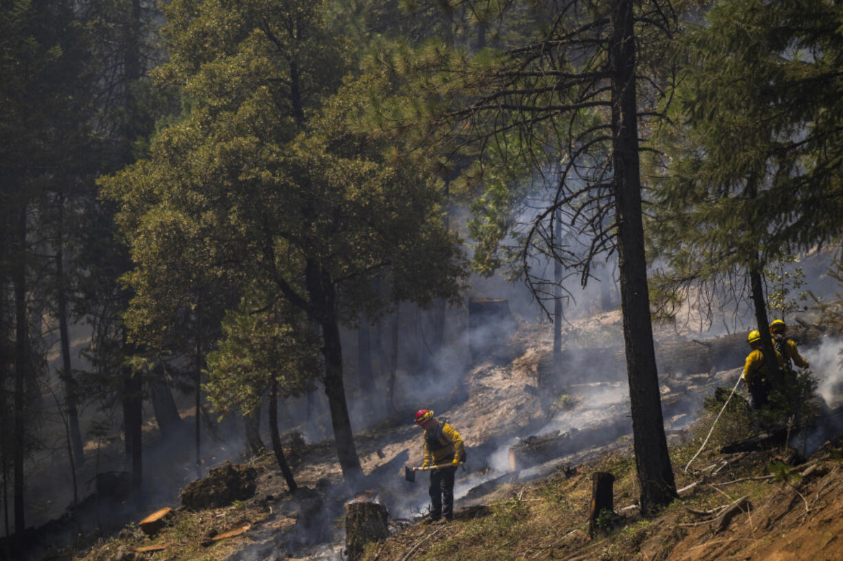 Firefighters put out hot spots from the Park Fire along Highway 32 near Forest Ranch, Calif., Tuesday, July 30, 2024.