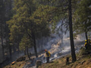 Firefighters put out hot spots from the Park Fire along Highway 32 near Forest Ranch, Calif., Tuesday, July 30, 2024.