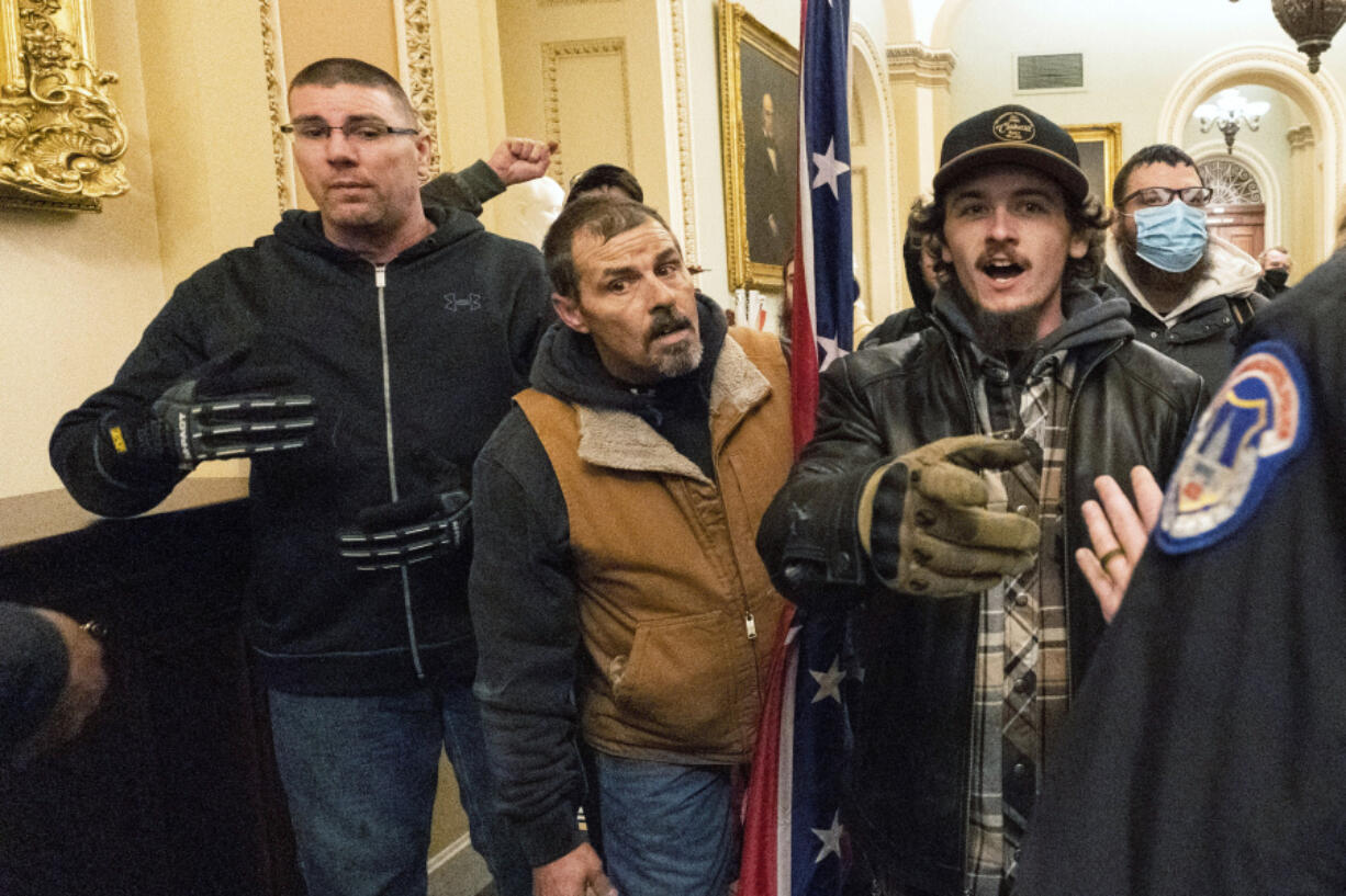 FILE - Michael Sparks, left, and Kevin Seefried, second from left, as they and other rioters loyal to President Donald Trump are confronted by U.S. Capitol Police officers outside the Senate Chamber inside the Capitol in Washington, Jan. 6, 2021.