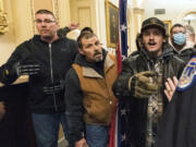 FILE - Michael Sparks, left, and Kevin Seefried, second from left, as they and other rioters loyal to President Donald Trump are confronted by U.S. Capitol Police officers outside the Senate Chamber inside the Capitol in Washington, Jan. 6, 2021.