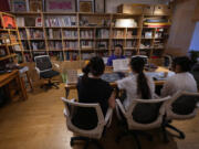 Xu Yan, an author of a textbook on n&uuml;shu, a centuries-old secret script, shows a book of n&uuml;shu calligraphy to the visiting university students at her studio in Beijing on July 11, 2024.