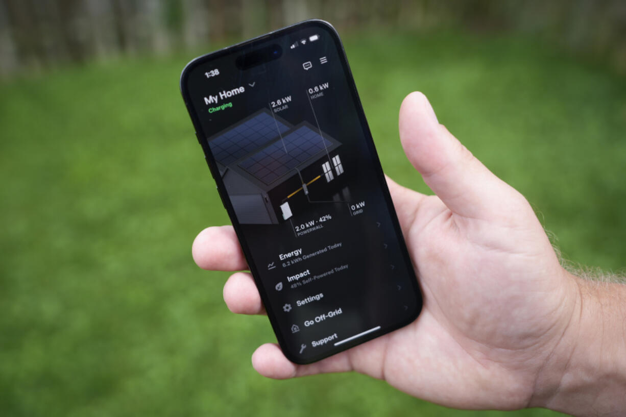 Jason Benedict shows an app on his phone with solar energy readings of his home in Berkley, Mich., Wednesday, July 24, 2024.