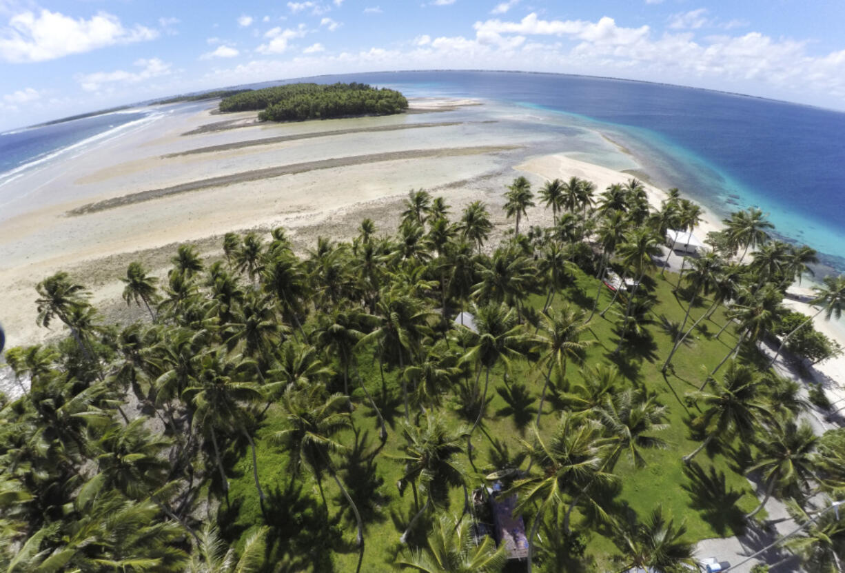 FILE - A section of land between trees is washed away due to rising seas on Nov. 6, 2015, in Majuro Atoll, Marshall Islands.