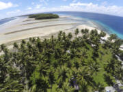 FILE - A section of land between trees is washed away due to rising seas on Nov. 6, 2015, in Majuro Atoll, Marshall Islands.