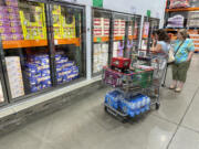 Shoppers consider items displayed in refrigerators at a Costco warehouse Aug. 22, 2024, in Parker, Colo.