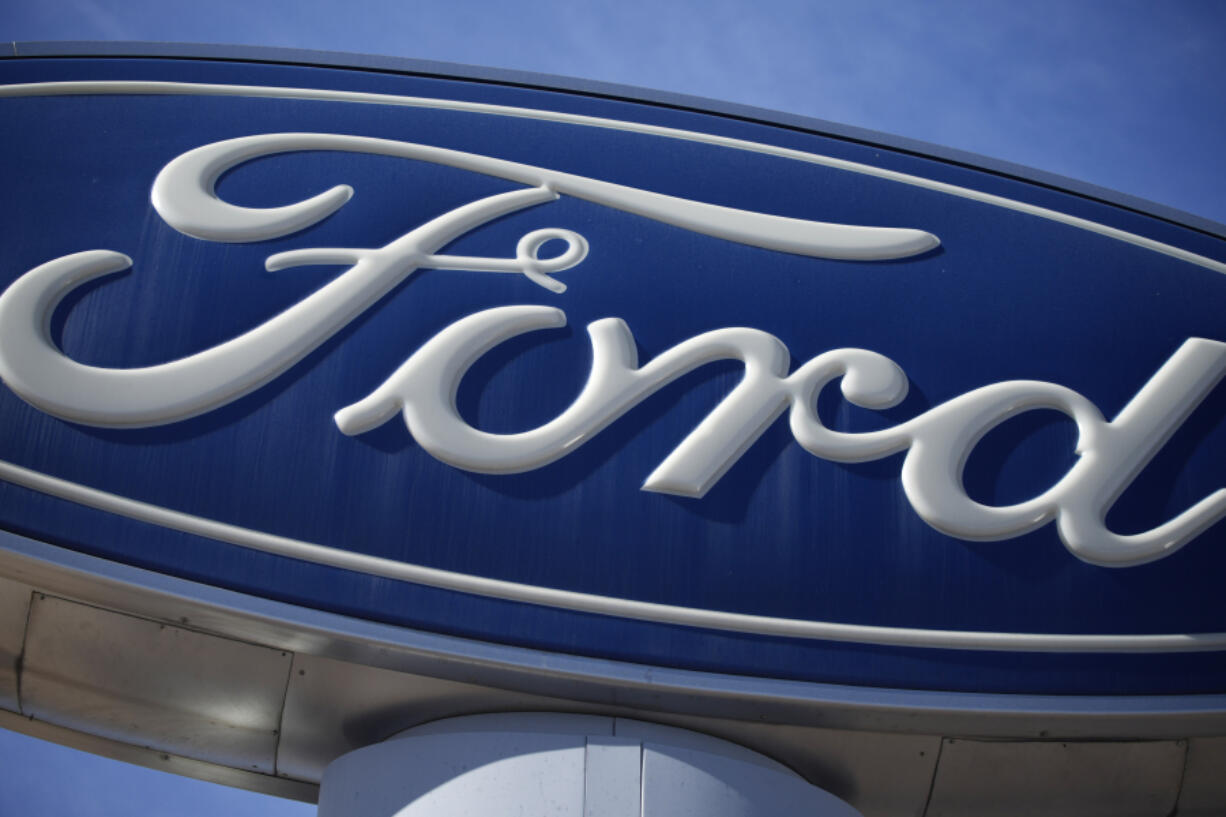 FILE - This Oct. 24, 2021 file photo shows a Ford company logo on a sign at a Ford dealership in southeast Denver.