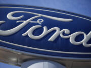 FILE - This Oct. 24, 2021 file photo shows a Ford company logo on a sign at a Ford dealership in southeast Denver.