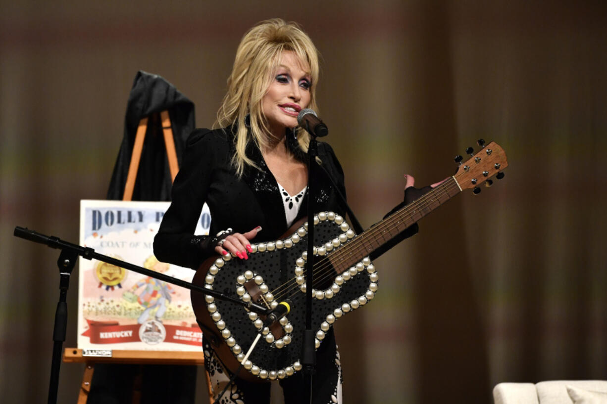 Dolly Parton plays to a audience gathered Tuesday to celebrate the expansion of the Imagination Library of Kentucky at the Lyric Theatre in Lexington, Ky. The library is now available to all 120 counties of Kentucky and provides free books to children up to the age of 5. (Timothy D.