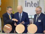 FILE - President Joe Biden listens to Intel CEO Pat Gelsinger, left, as Intel factory manager Hugh Green watches during a tour of the Intel Ocotillo Campus, in Chandler, Ariz., on March 20, 2024. Intel reports earnings on Thursday, Aug. 1, 2024.