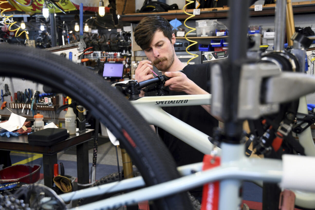 FILE - Mechanic Thomas Strater works at University Bicycles in Boulder, Colo., April 30, 2024. U.S. hiring decelerated sharply in July in the face of high interest rates as employers added a weak 114,000 jobs.