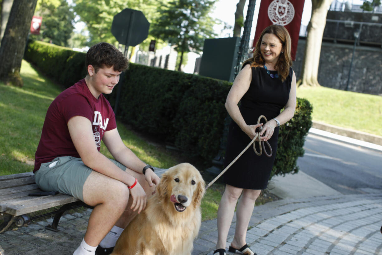 Tania Tetlow president of Fordham University holds her dog Archie as new students arrive during Move In Day at the Bronx campus, Sunday Aug. 25, 2024, in New York.