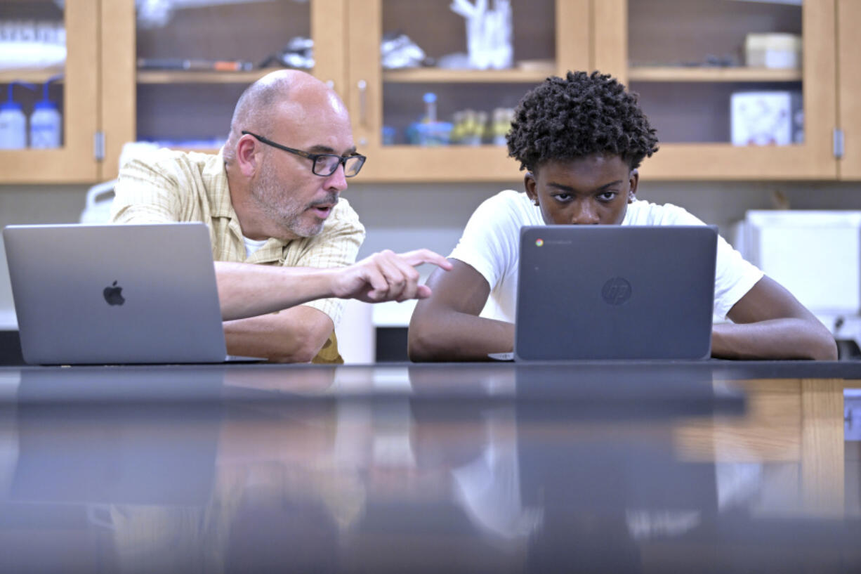 History teacher Matt Brophy, left, works with Flerentin &ldquo;Flex&rdquo; Jean-Baptiste, 16, on making up late assignments Aug. 2 during summer school at Medford High School in Medford, Mass.