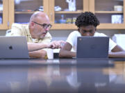 History teacher Matt Brophy, left, works with Flerentin &ldquo;Flex&rdquo; Jean-Baptiste, 16, on making up late assignments Aug. 2 during summer school at Medford High School in Medford, Mass.