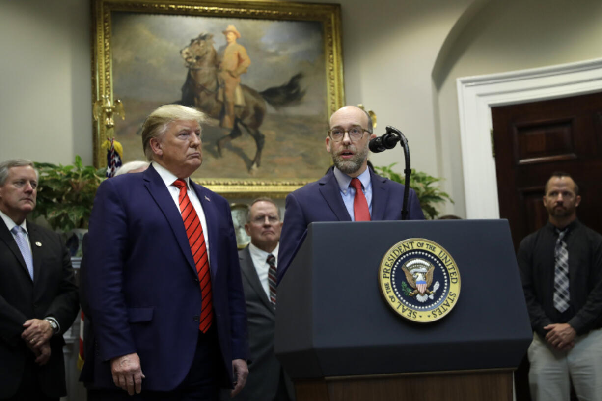 FILE - President Donald Trump listens as acting director of the Office of Management and Budget Russel Vought speaks during an event on &ldquo;transparency in Federal guidance and enforcement&rdquo; in the Roosevelt Room of the White House, Wednesday, Oct. 9, 2019, in Washington.